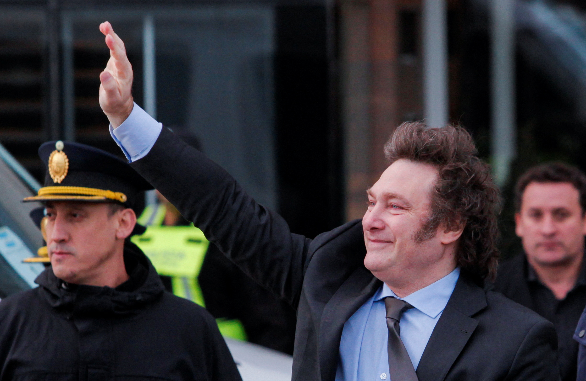 Argentina's President Javier Milei waves to supporters outside the hotel where he will stay before traveling to Antartica, in Rio Gallegos