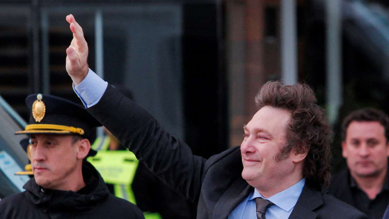 Argentina's President Javier Milei waves to supporters outside the hotel where he will stay before traveling to Antartica, in Rio Gallegos