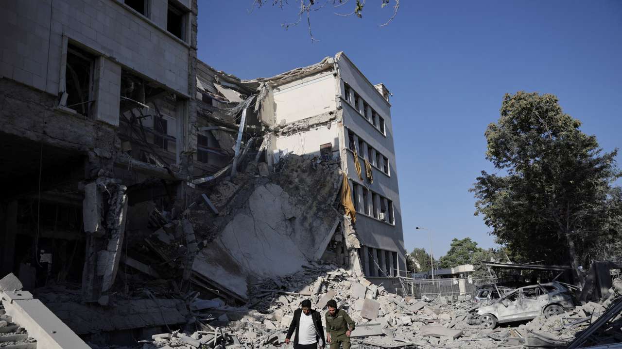People gather near a damaged site, in Damascus