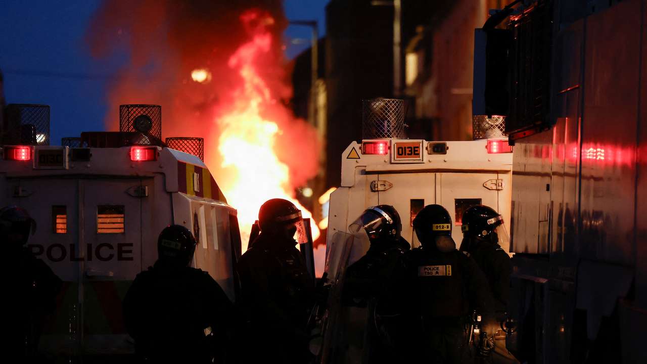Armed police in riot gear stand guard during a second night of riots, in Ballymena