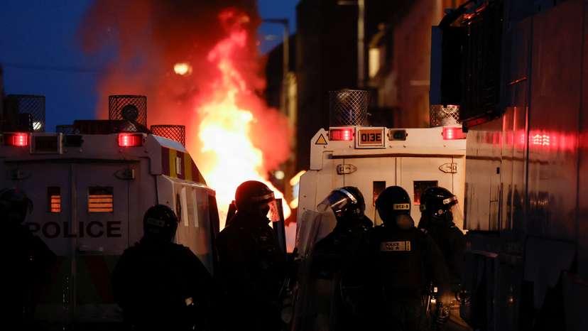 Armed police in riot gear stand guard during a second night of riots, in Ballymena