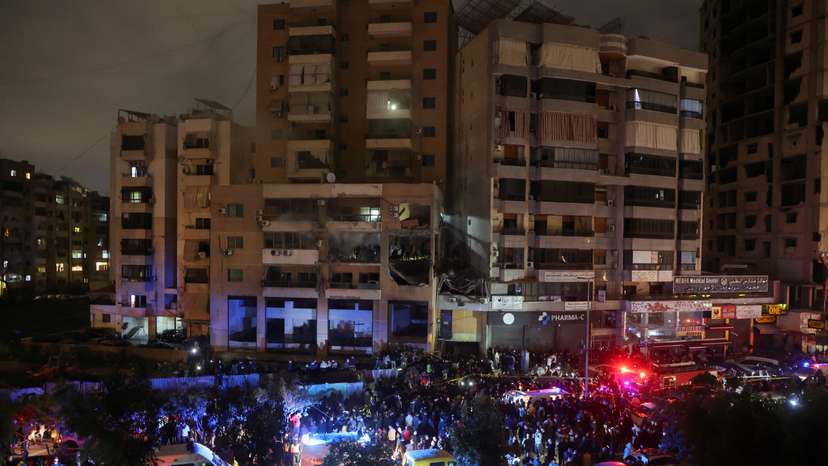 People gather near a damaged site following an explosion at Beirut suburb of Dahiyeh