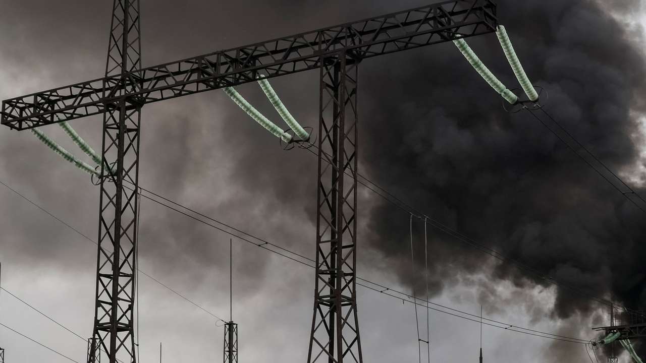 Smoke rises in the sky over a high-voltage line at a site of a Russian missile strike outside Kharkiv