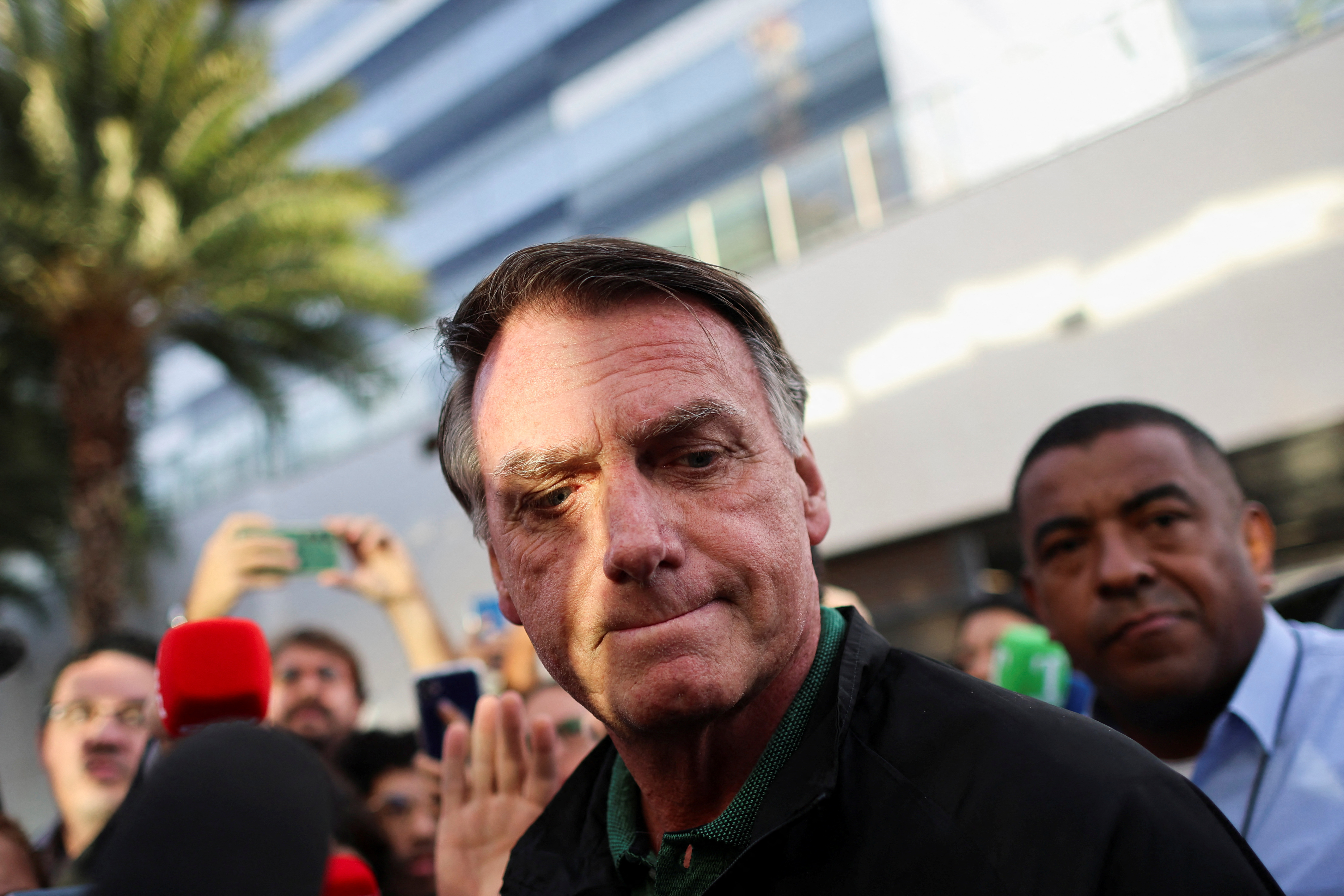Former Brazilian President Jair Bolsonaro reacts as he leaves the Federal Police headquarters after testifying, in Brasilia