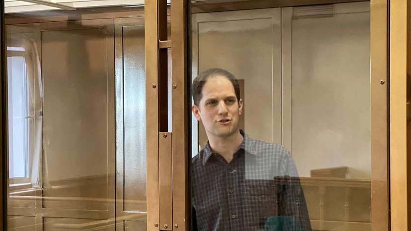 FILE PHOTO: Wall Street Journal reporter Evan Gershkovich stands behind a glass wall of an enclosure for defendants as he attends a court hearing to consider extending his detention in Moscow