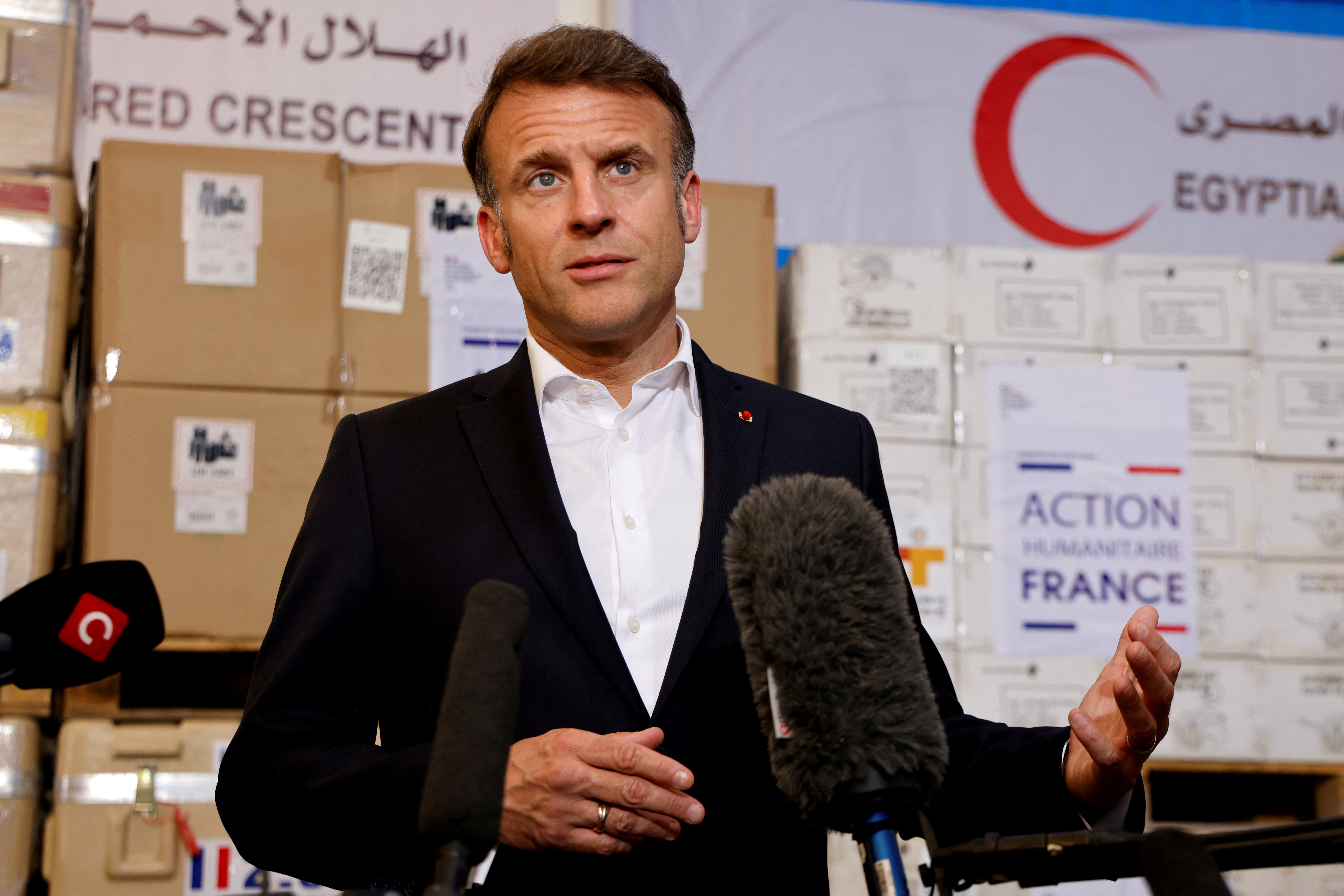 France's President Macron speaks in front of humanitarian aid destined to Gaza, in Arish