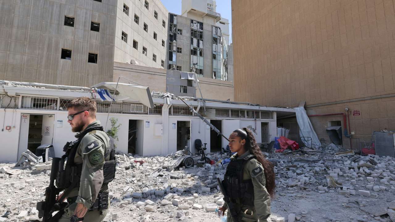 Members of the Israeli security forces walk near the Soroka Medical Center, after it was hit by a missile fired from Iran, in Beersheba