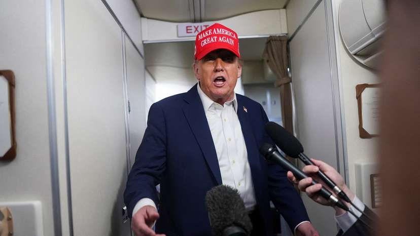 U.S. President Donald Trump speaks to members of the media on board Air Force One on the way to New Jersey