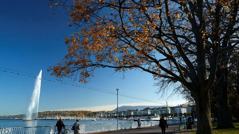 FILE PHOTO: People walk near lake Leamn and the jet d'eau water fountain in Geneva