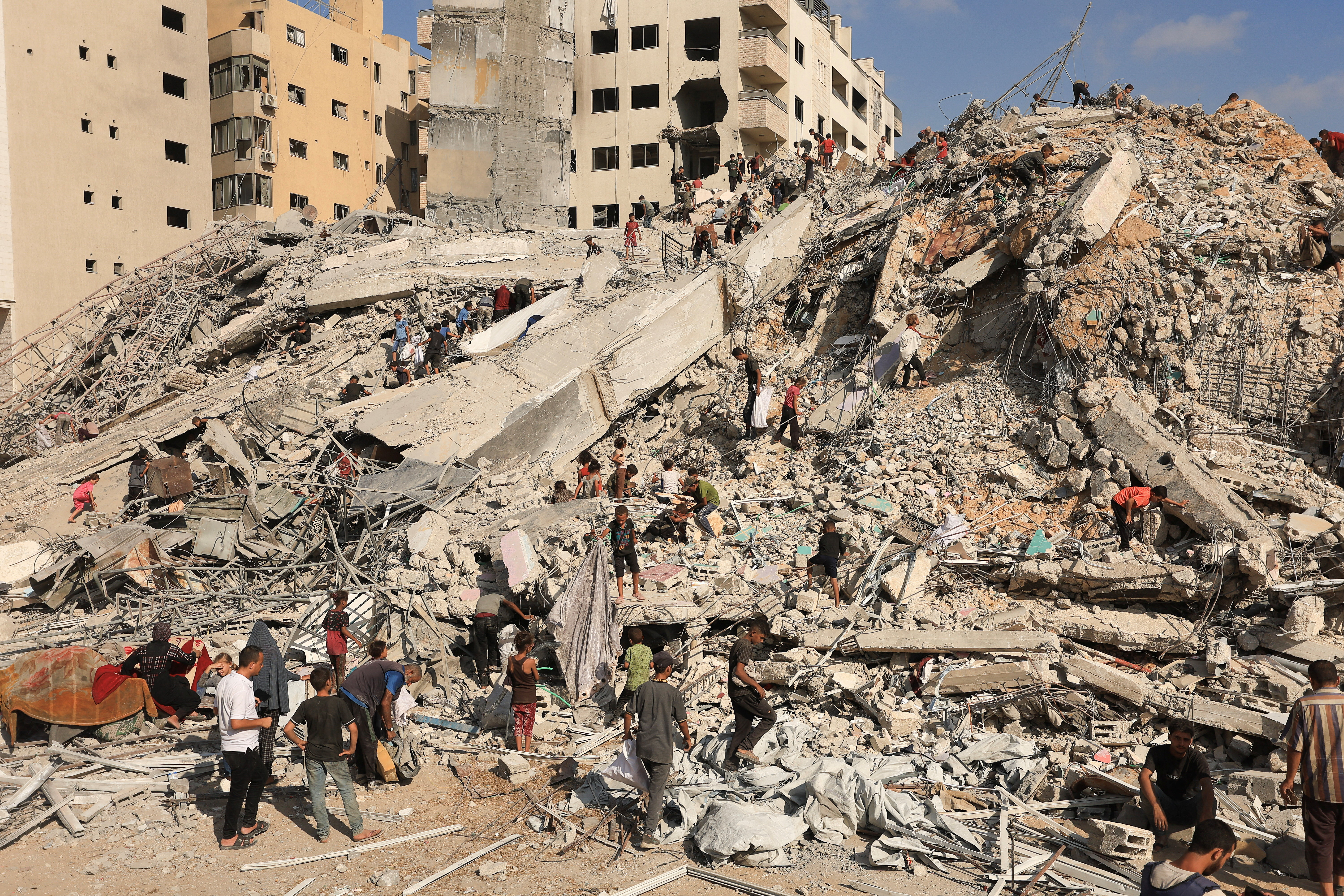 Palestinians inspect the site of an Israeli air strike that destroyed a residential building, in Gaza City