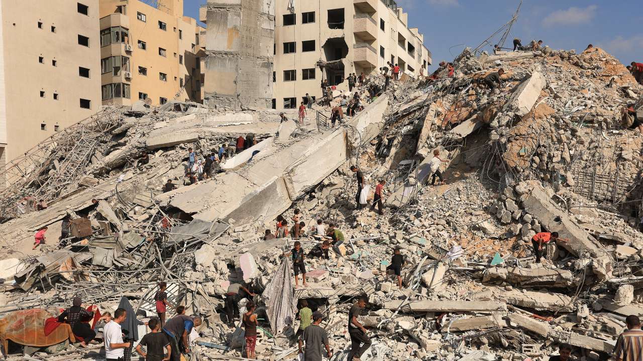 Palestinians inspect the site of an Israeli air strike that destroyed a residential building, in Gaza City