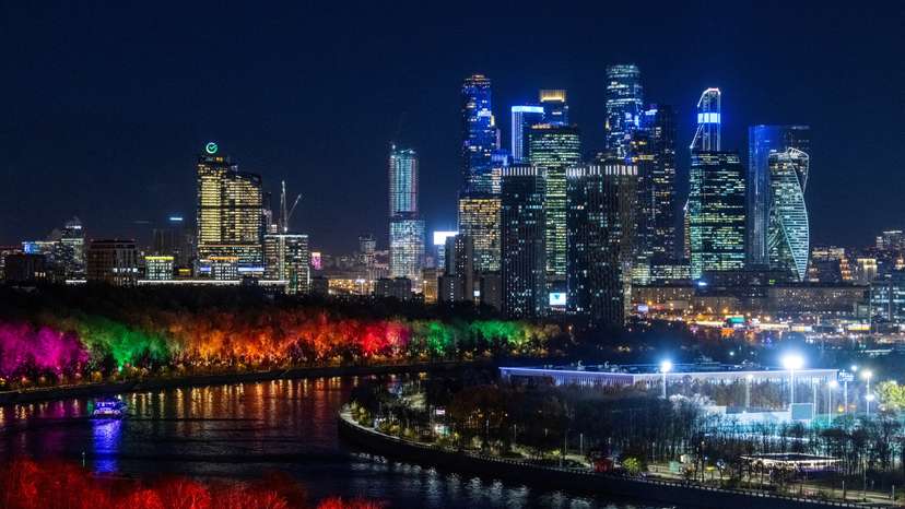 A view of Moscow City International Business District and Moskva river with its embankment illuminated with colorful lights in Moscow