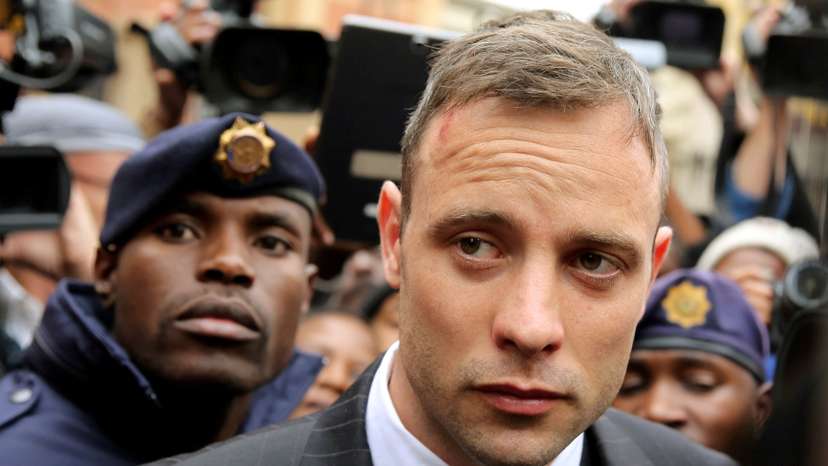 Olympic and Paralympic track star Oscar Pistorius leaves court after appearing for the 2013 killing of his girlfriend Reeva Steenkamp