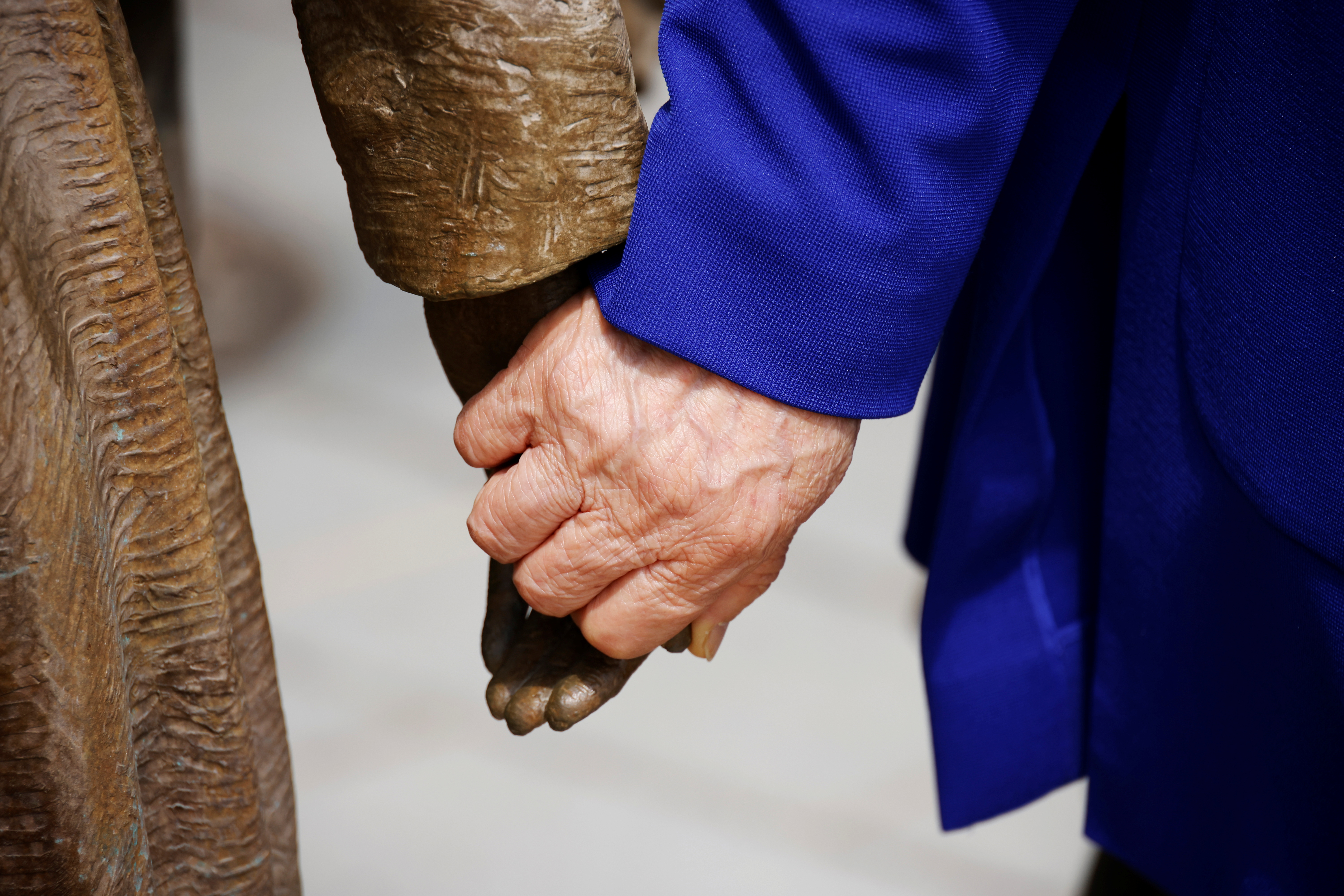 Former South Korean "comfort woman" Lee Yong-soo holds the hand of a statue symbolising "comfort women" at the Seoul Comfort Women Memorial in Seoul
