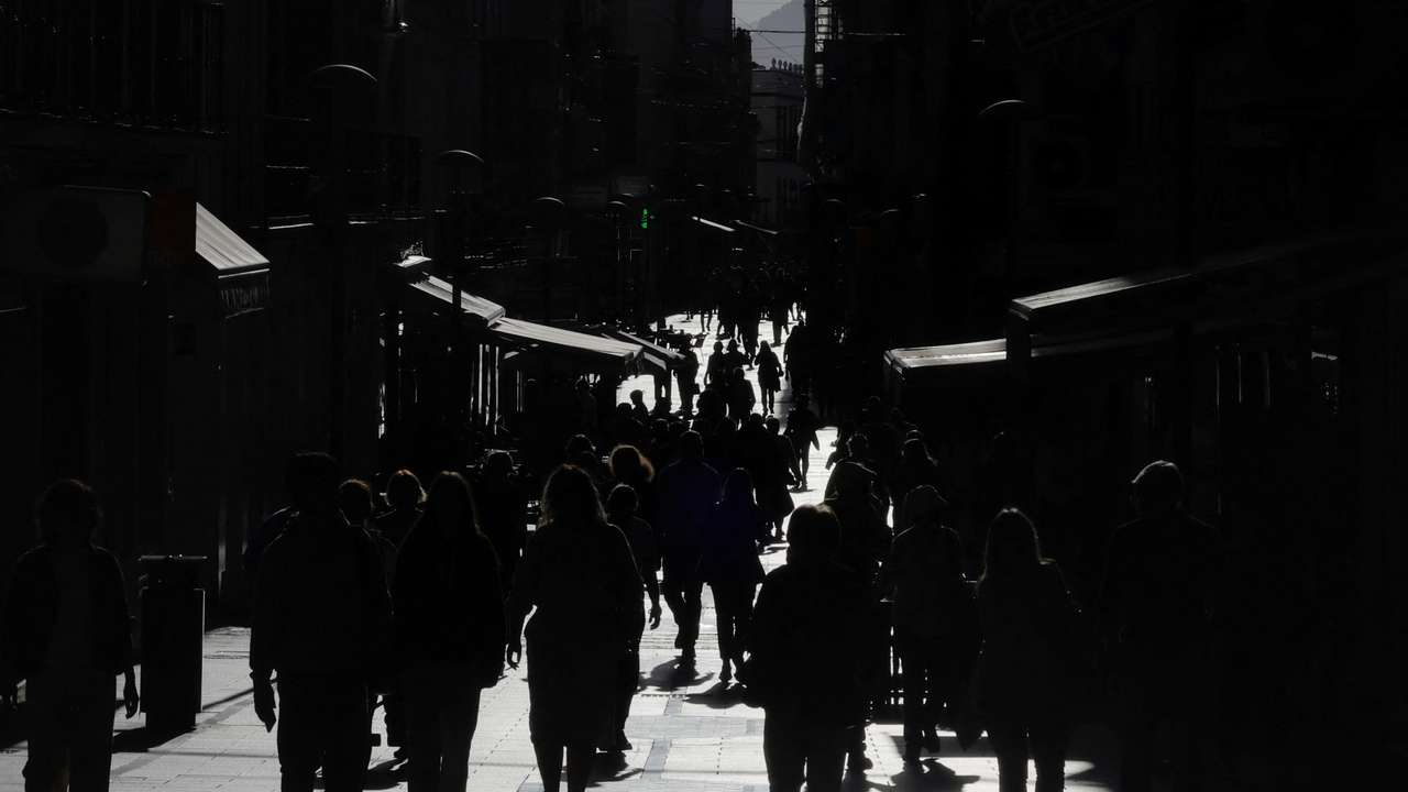 People walk along La Bola shopping street during sunset in Ronda