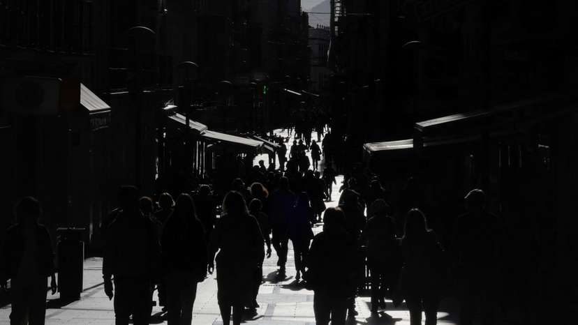 People walk along La Bola shopping street during sunset in Ronda