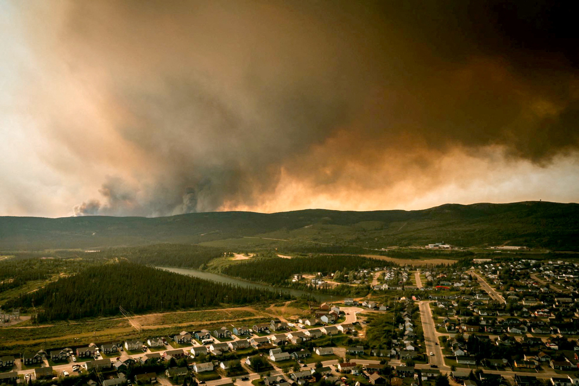 FILE PHOTO: Smoke from an encroaching wildfire is seen over homes after an evacuation was ordered in the eastern Canadian community of Labrador City