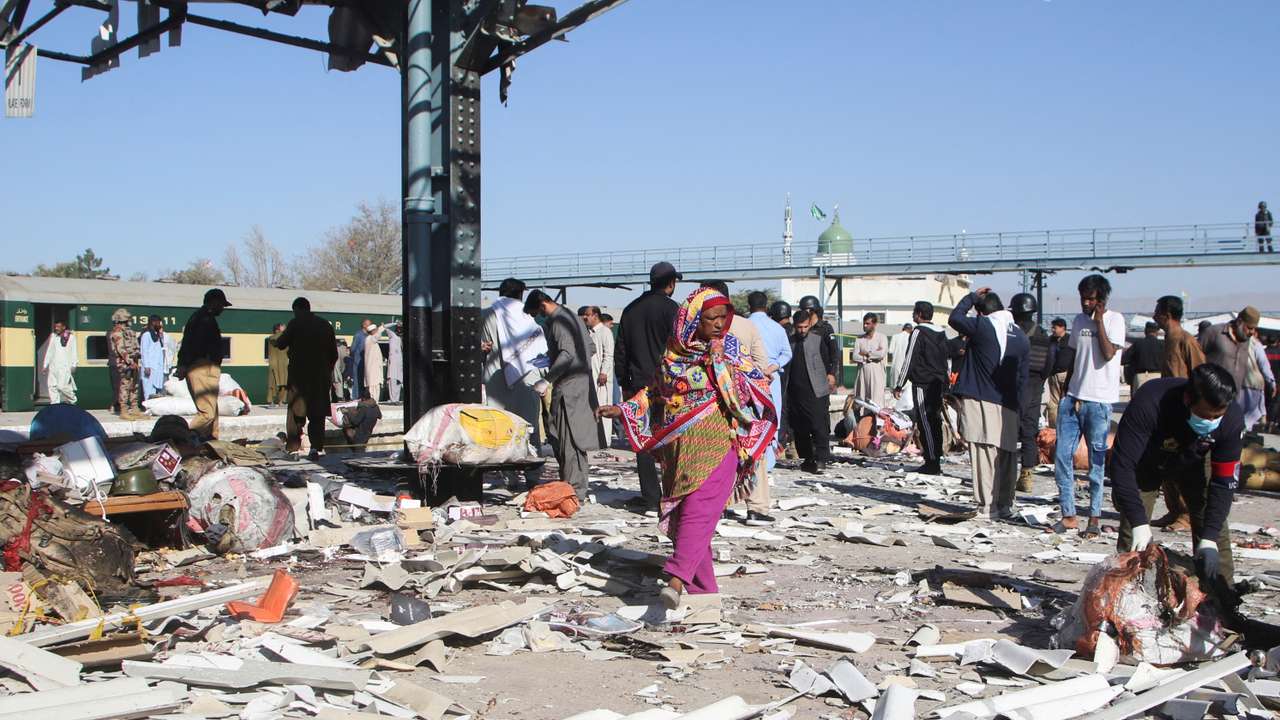 Woman walks amid the debris after a bomb blast at a railway station in Quetta