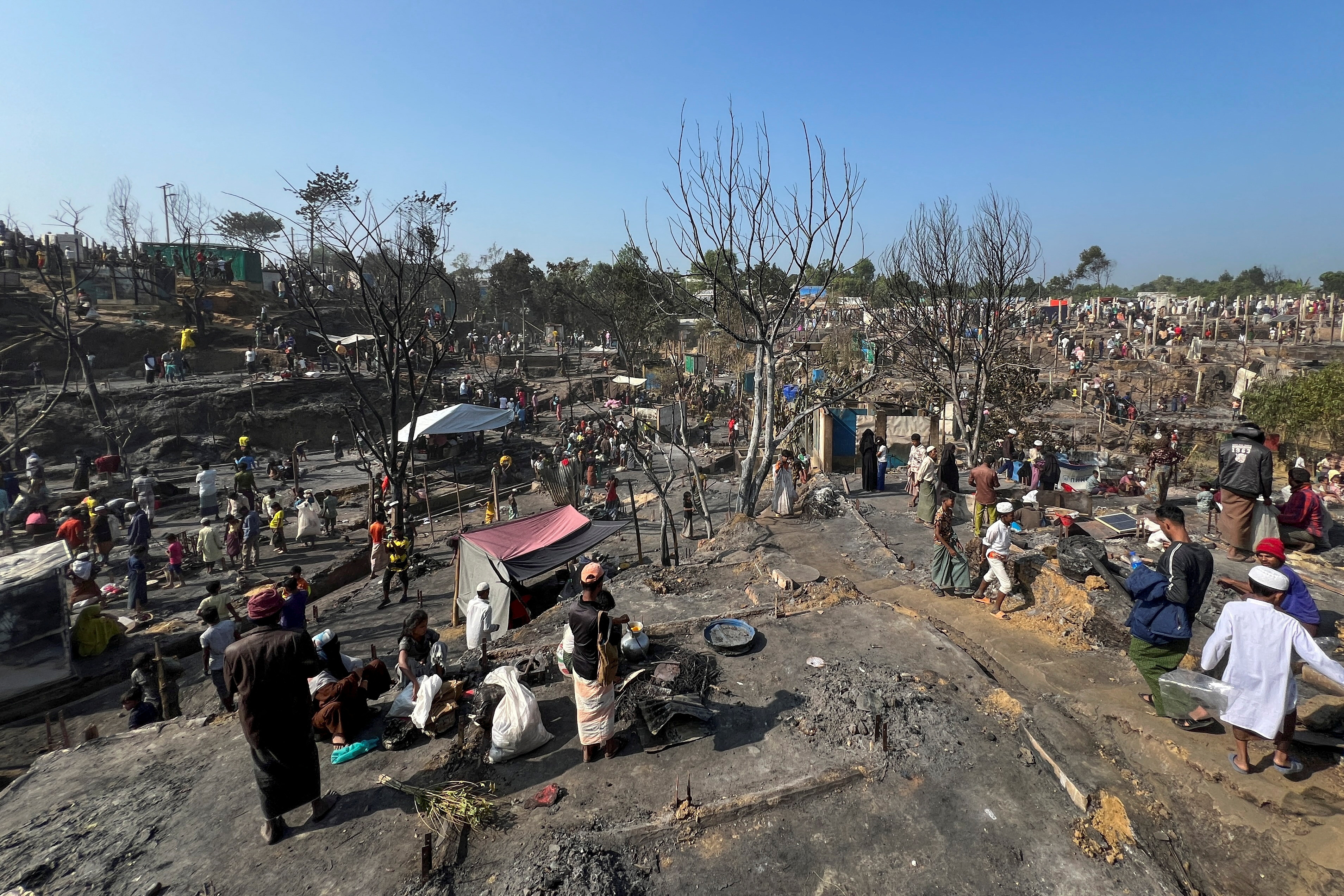 Rohingya refugees work on rebuilding their makeshift shelters after a fire broke out in a camp in Cox's Bazar