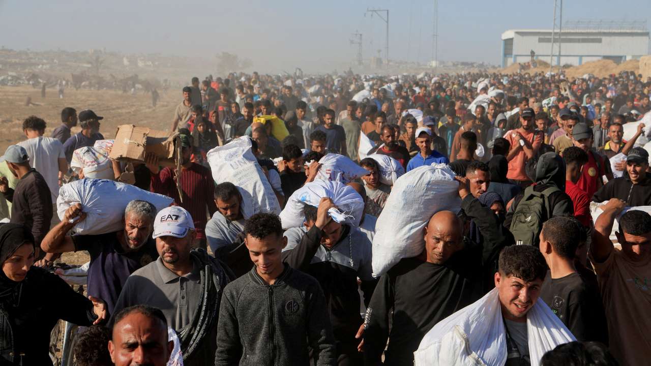 FILE PHOTO: Palestinians carry aid supplies from the U.S.-backed Gaza Humanitarian Foundation, in Khan Younis