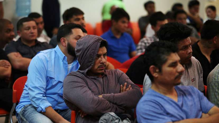 FILE PHOTO: Deportees wait to be processed at an immigration facility after a flight carrying illegal immigrants from the U.S. arrived in San Salvador