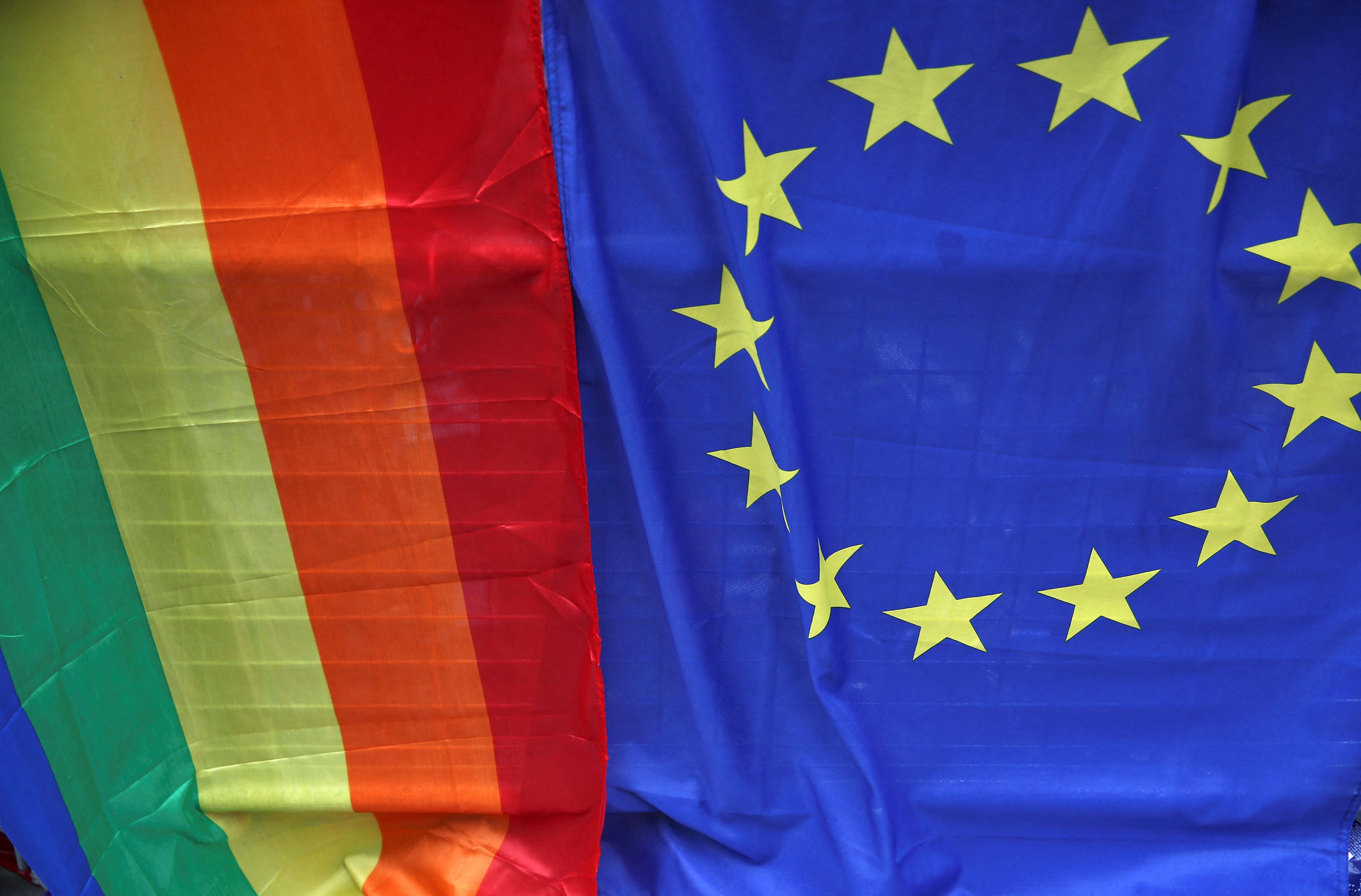 FILE PHOTO: A European Union flag is displayed alongside a Rainbow flag during the annual Pride London Parade in London