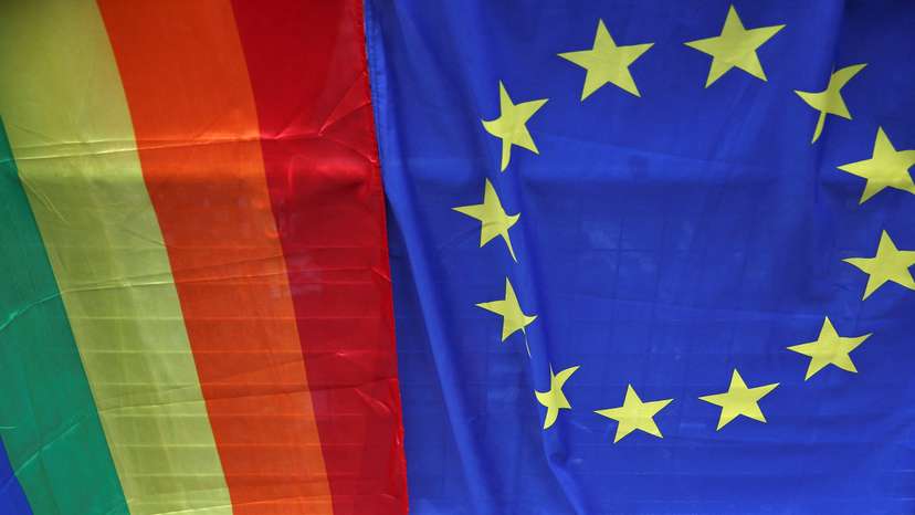 FILE PHOTO: A European Union flag is displayed alongside a Rainbow flag during the annual Pride London Parade in London