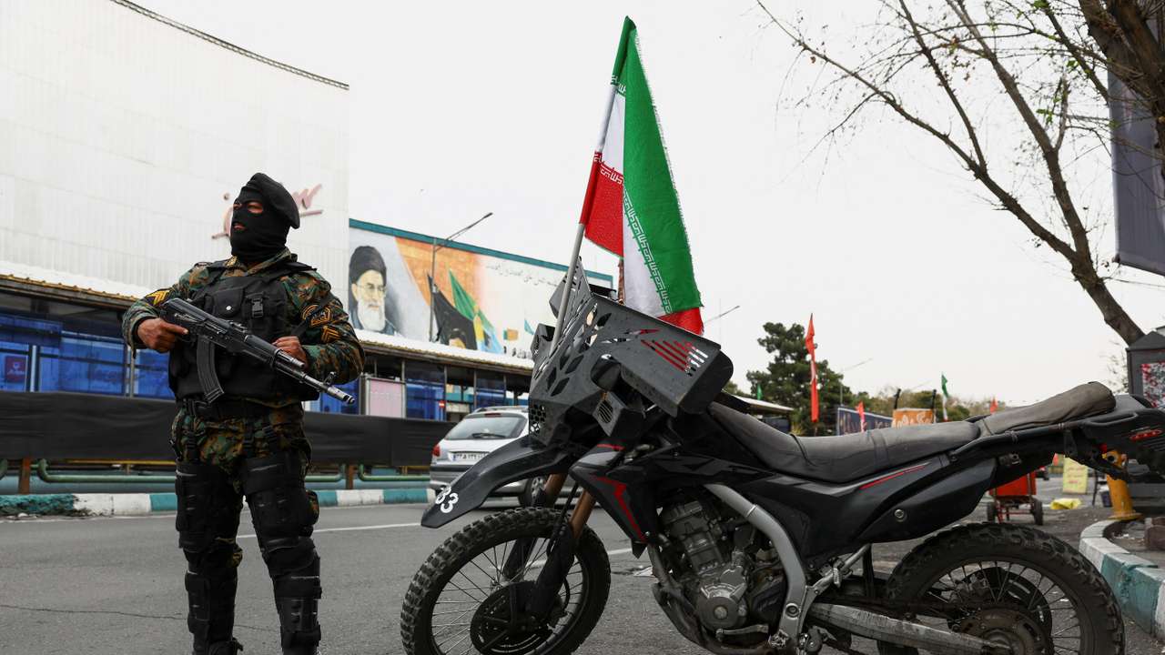 A member of a police force stands guard on a street, amid the U.S.-Israeli conflict with Iran, in Tehran