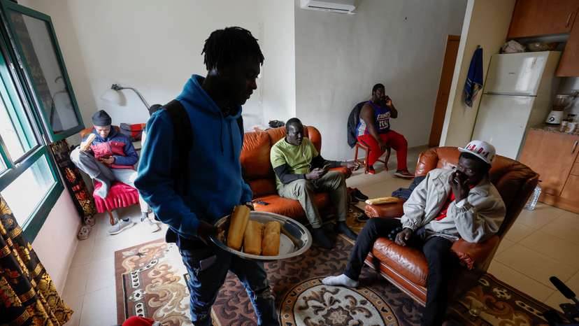 Senegal former fisherman Khalifa Ndou sits to have a drink at Papa Sidi Ngom's apartment in Guissona town
