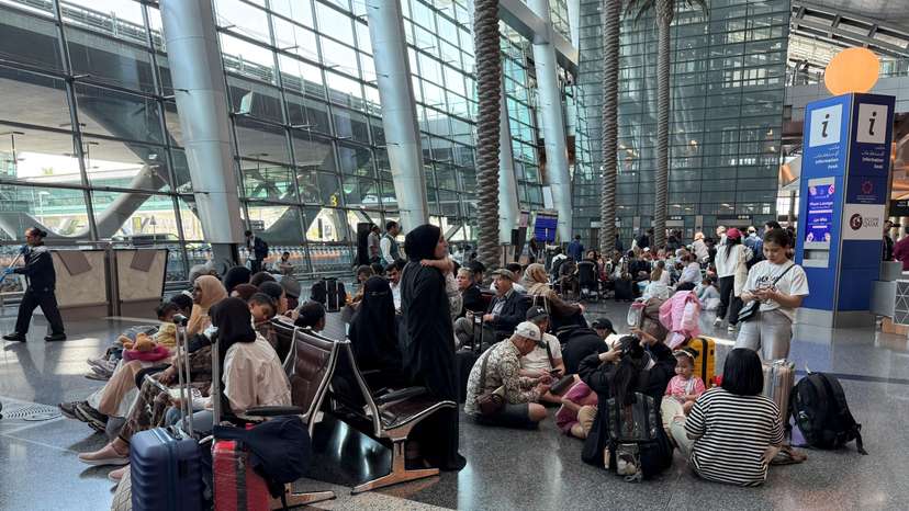 People sit at Hamad International Airport, in Doha