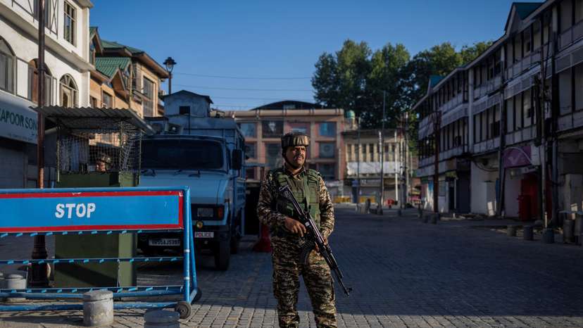 An Indian security force personnel stands guard on a street in Srinagar