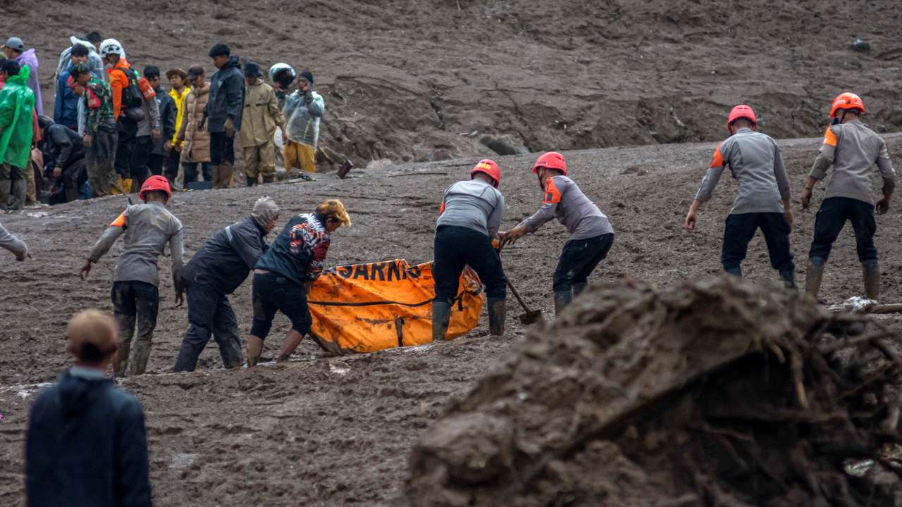 Indonesian rescue members carry a body bag containing the remains of a victim from the site of a landslide after it hit Pasirlangu village, West Bandung