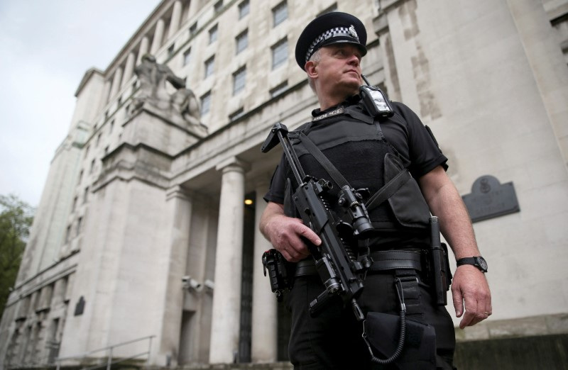 FILE PHOTO: An armed police officer patrols near the Ministry of Defence in London