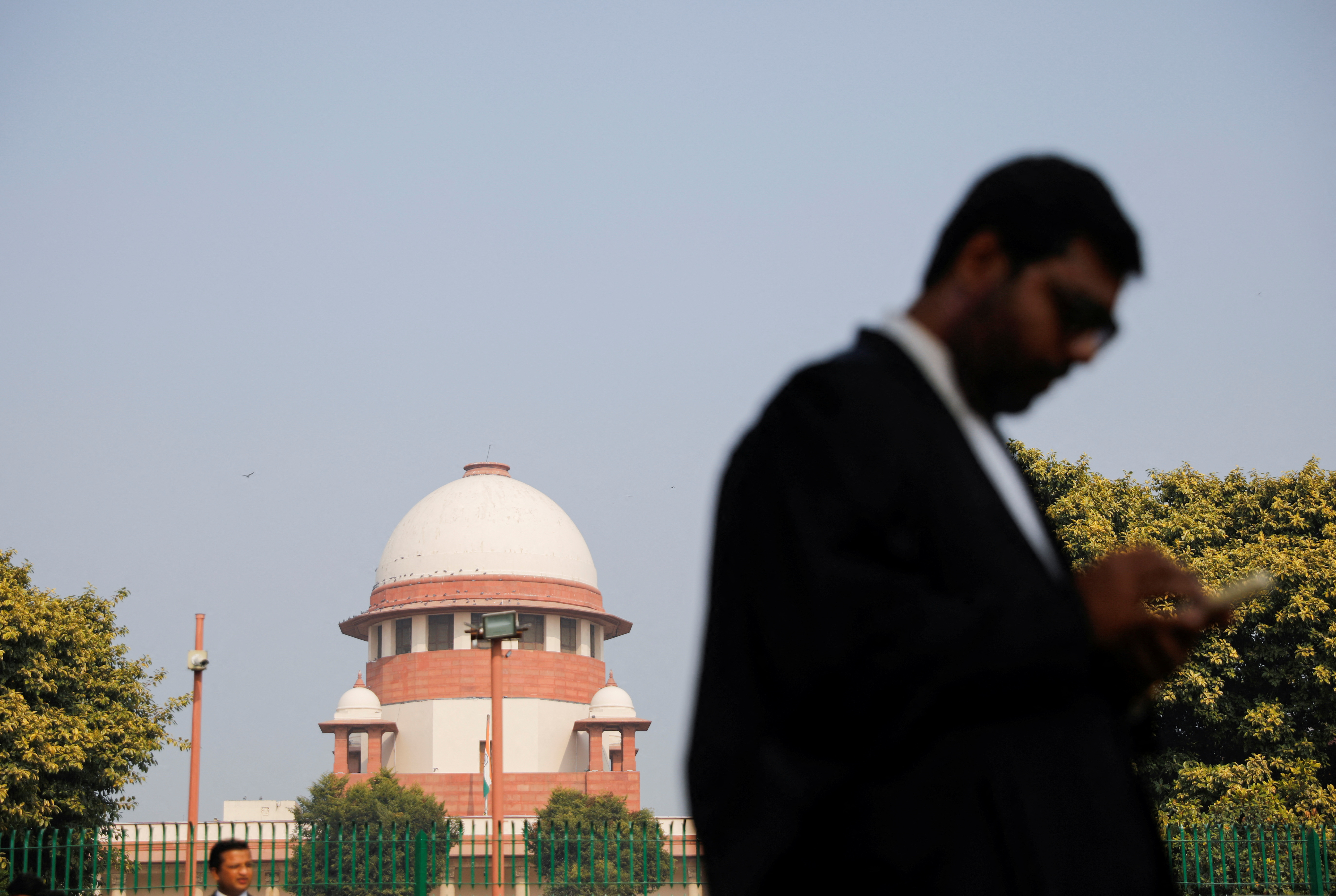 A lawyer looks into his mobile phone in front India's Supreme Court in New Delhi