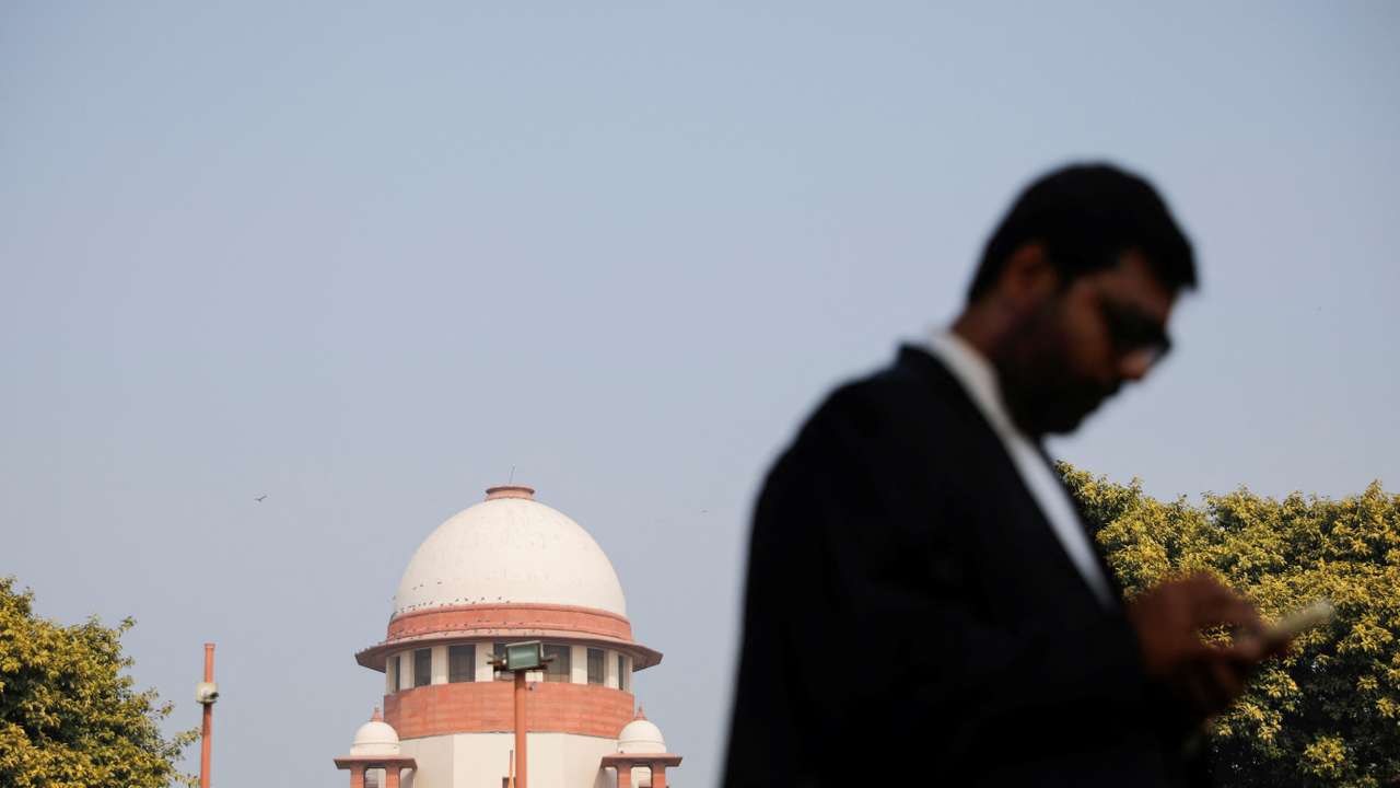 A lawyer looks into his mobile phone in front India's Supreme Court in New Delhi