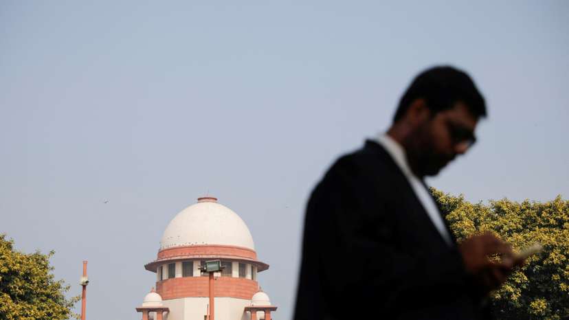 A lawyer looks into his mobile phone in front India's Supreme Court in New Delhi