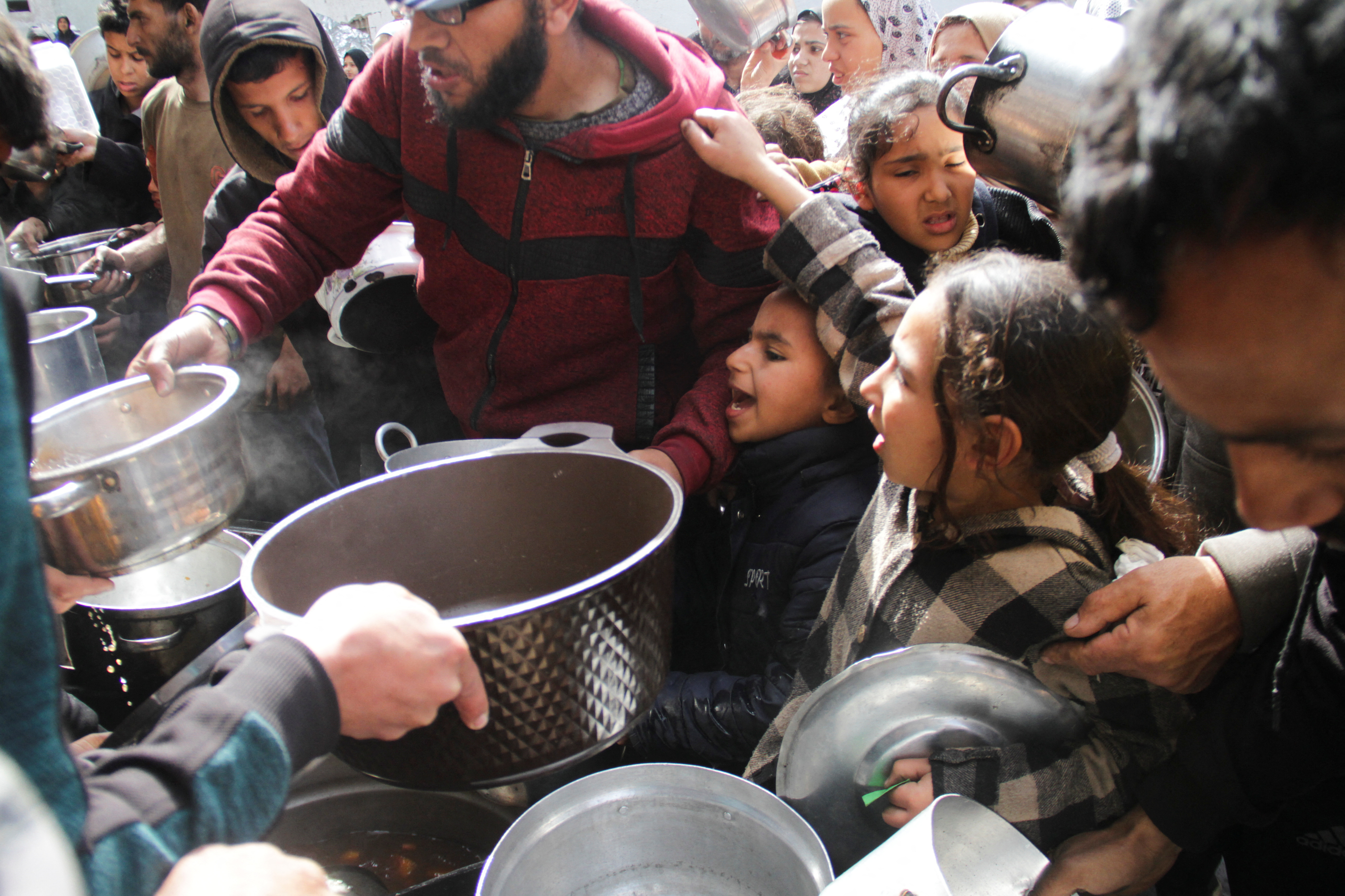 Palestinians gather to receive free food in Jabalia in the northern Gaza Strip