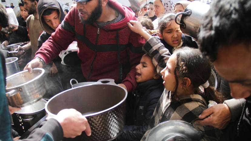 Palestinians gather to receive free food in Jabalia in the northern Gaza Strip