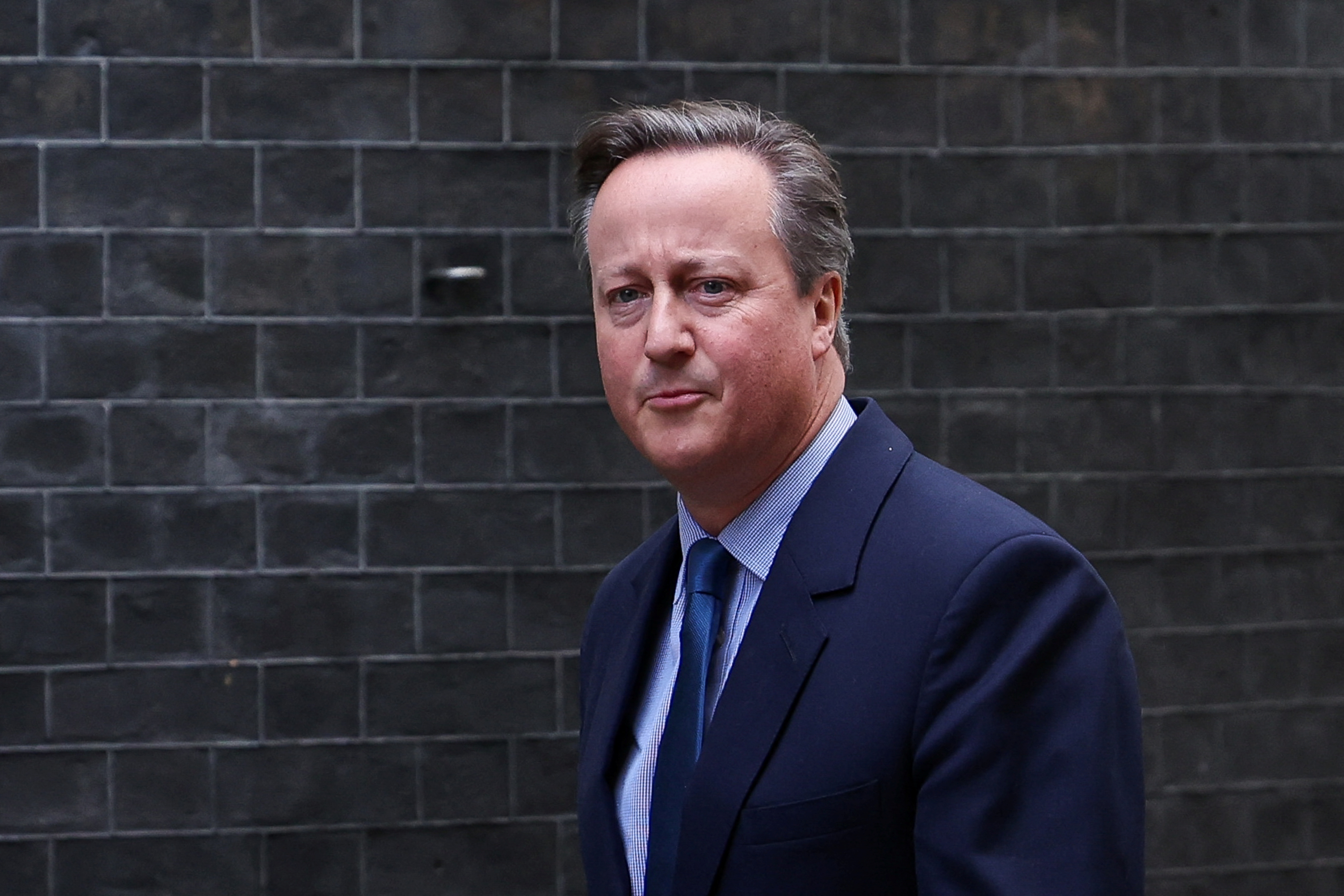 Former British Prime Minister David Cameron walks outside 10 Downing Street in London