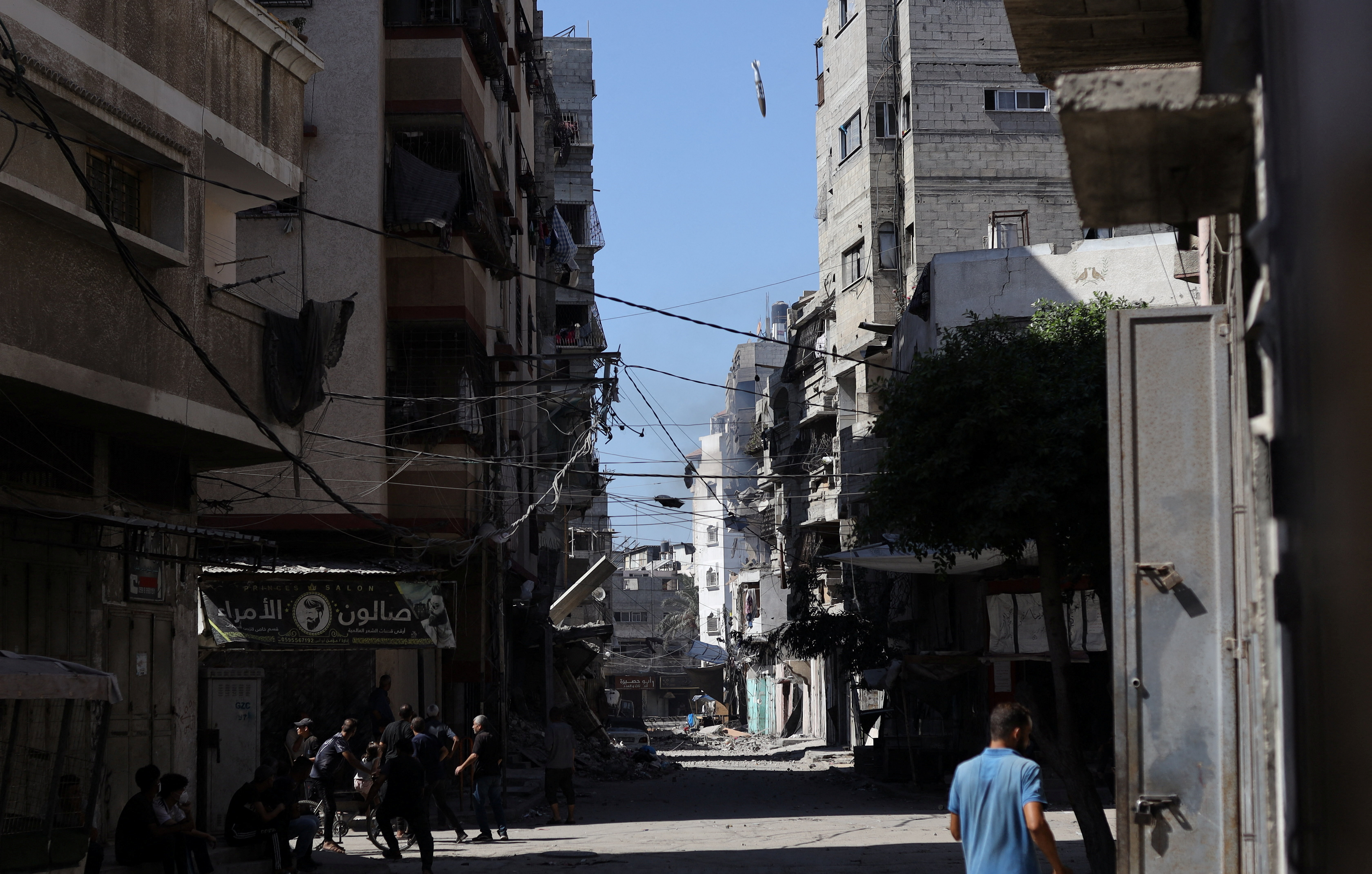 Palestinians react as a missile falls towards a house during an Israeli airstrike, in Gaza City