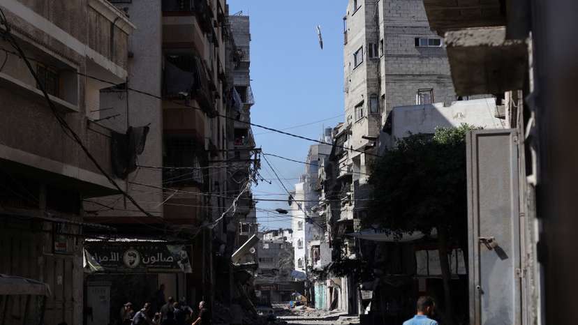 Palestinians react as a missile falls towards a house during an Israeli airstrike, in Gaza City