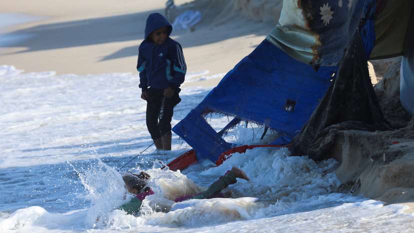 A child falls into the sea as Palestinians shelter in tents during a ceasefire between Israel and Hamas, in Khan Younis, southern Gaza Strip