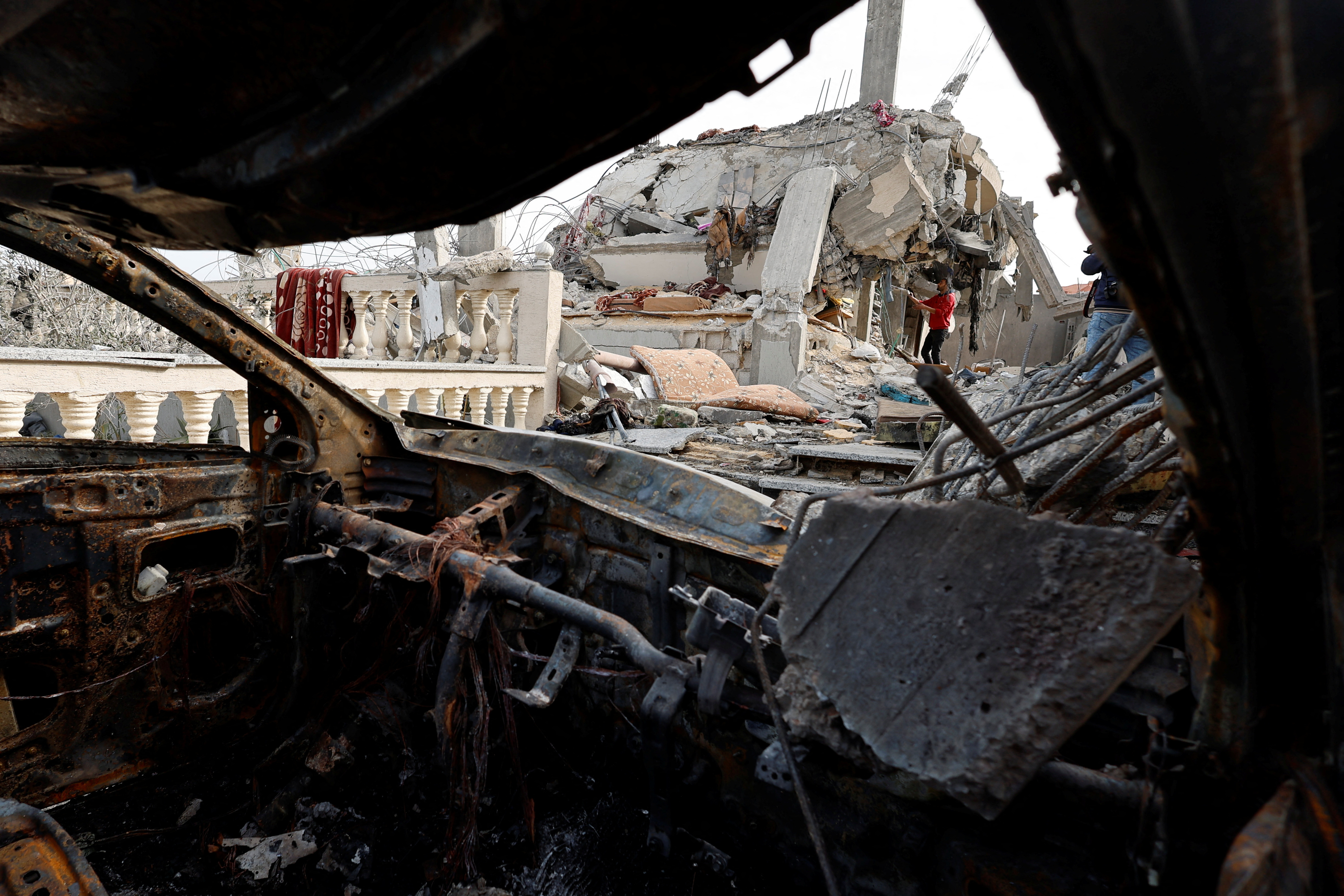Palestinians inspect the site of an Israeli strike on a house, in Rafah, in the southern Gaza Strip