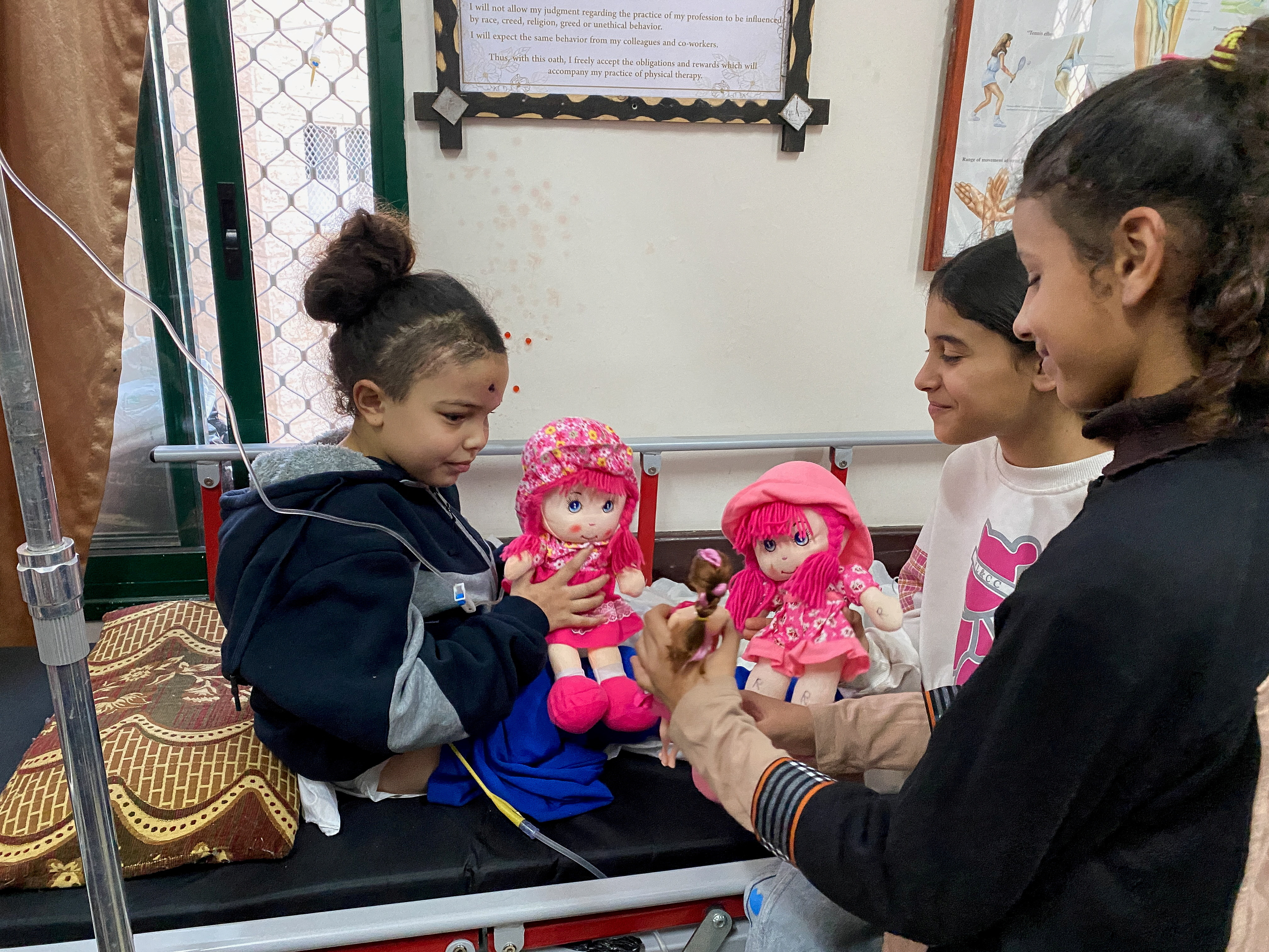 Displaced orphaned Palestinian girl plays with dolls at hospital in Deir Al-Balah