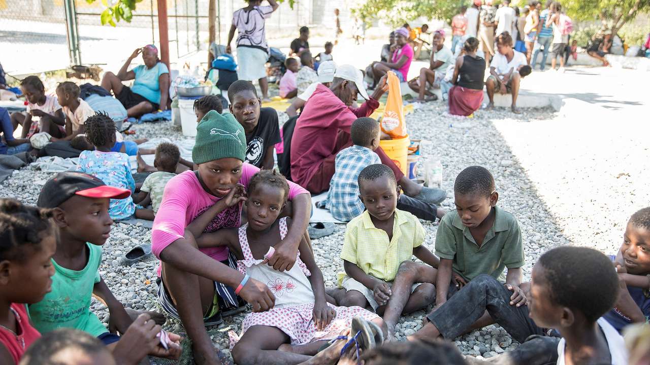 FILE PHOTO: People fleeing from violence after the murder of a local gang leader camp out in the courtyard of Cite Soleil's town hall, in Port-au-Prince