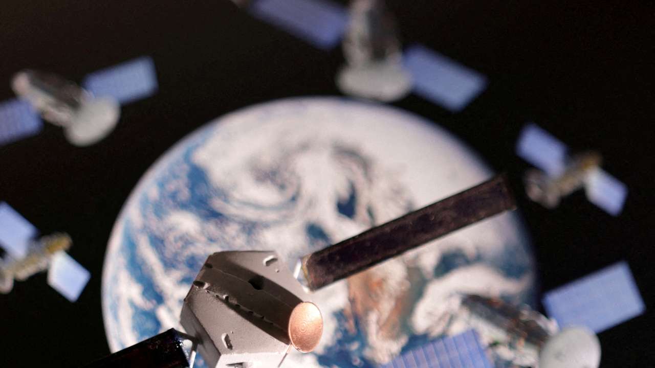 FILE PHOTO: Illustration shows a satellite model placed on picture of Earth