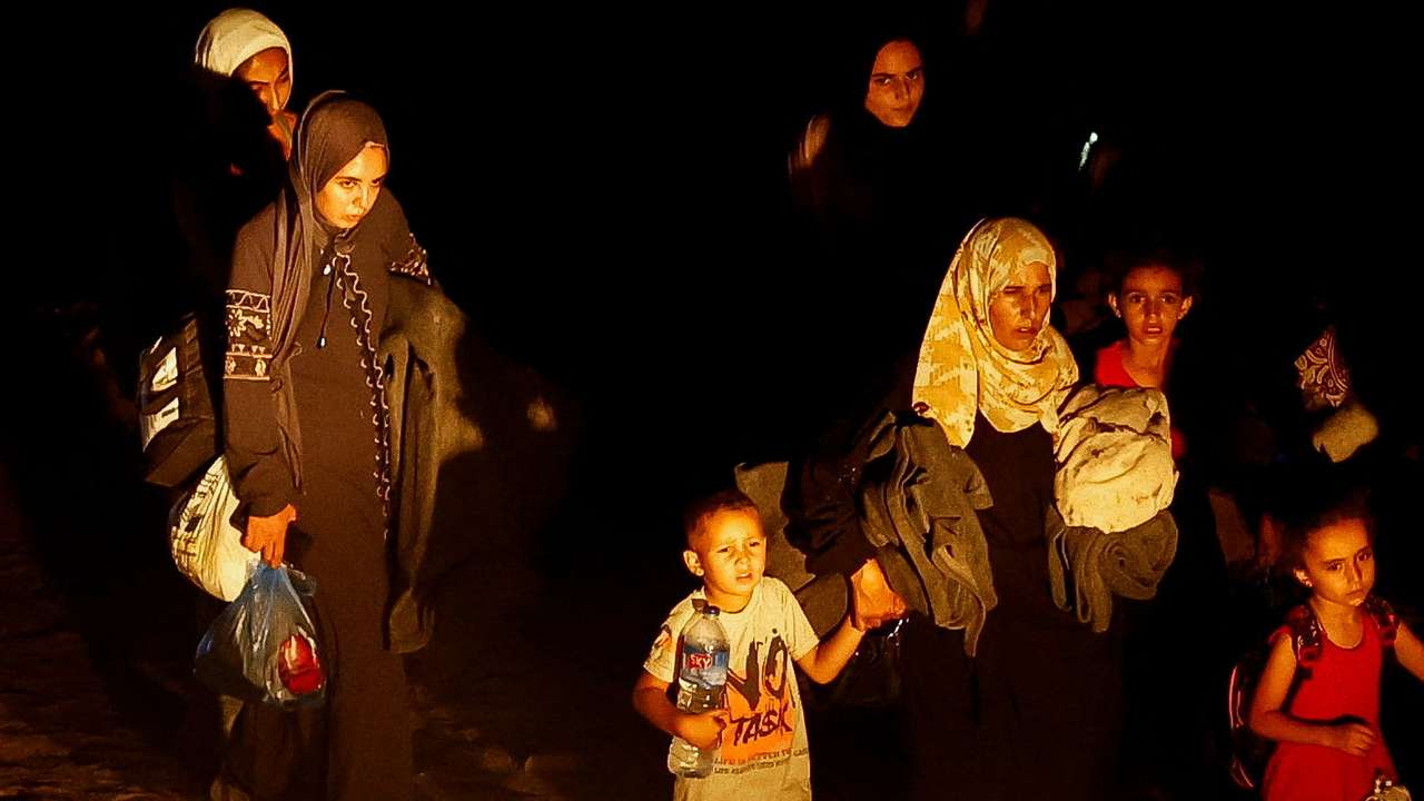 Palestinians, who fled the eastern part of Khan Younis, walk, after they were ordered by Israeli army to evacuate their neighbourhoods, amid Israel-Hamas conflict, in Khan Younis