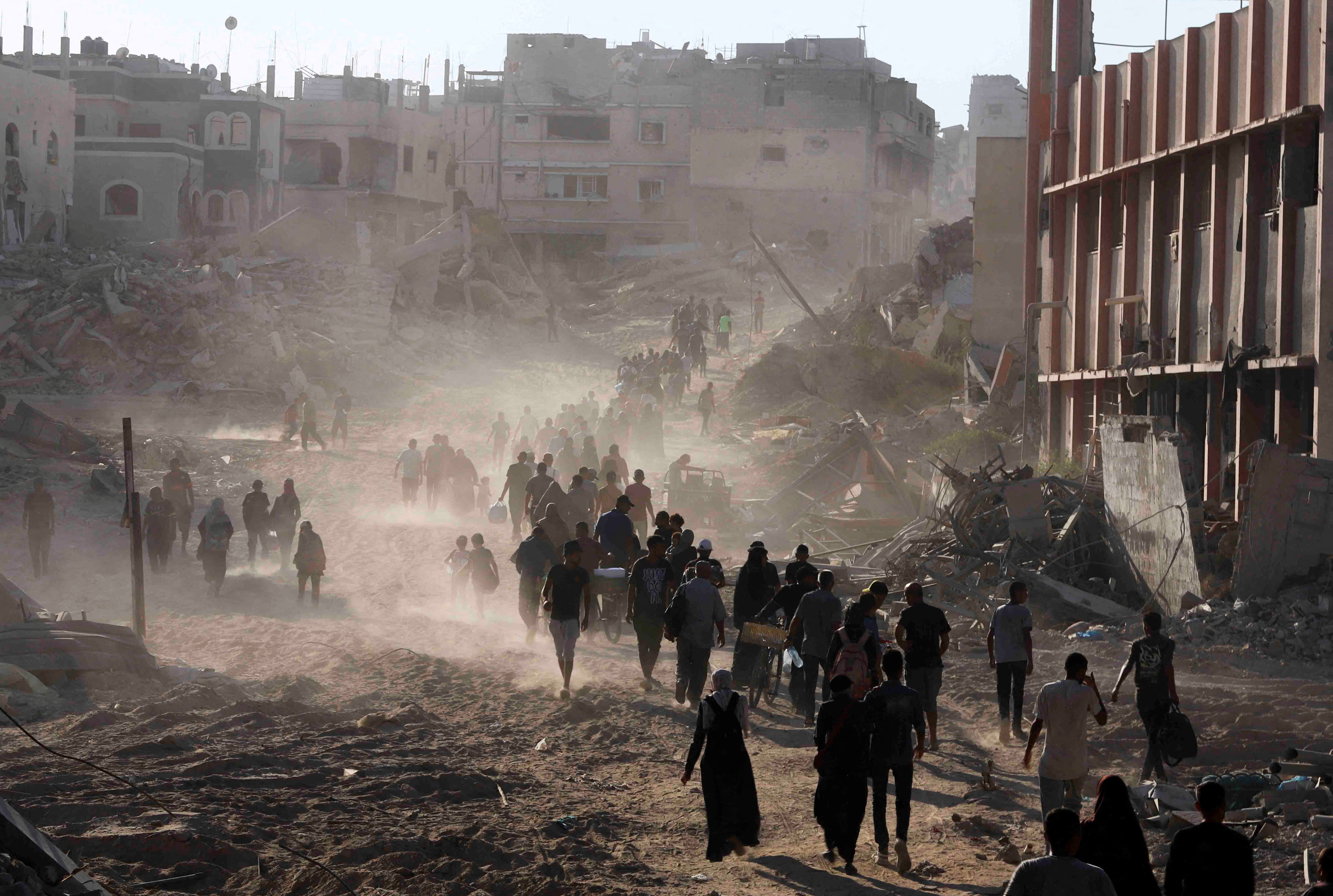 Palestinians return to the eastern side of Khan Younis after Israeli forces pulled out from the area in Khan Younis, in the southern Gaza Strip