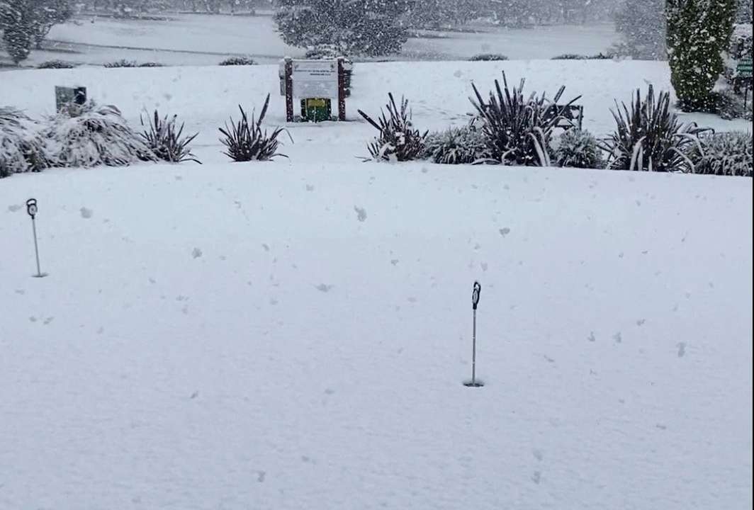 Snow blankets the grass at a Golf Club, in Armidale