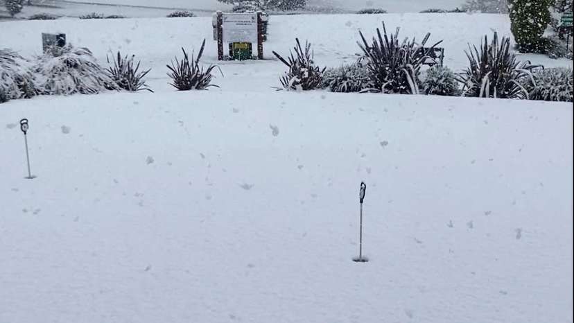 Snow blankets the grass at a Golf Club, in Armidale